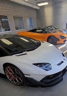 two white and orange sports cars parked in a garage