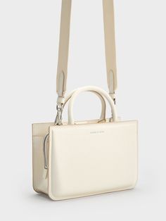 This product is made with at least 20% sustainable materials by weight. CHARLES & KEITH uses recycled, degradable, organic, and water-based materials in our eco-conscious collection. In search of a new wardrobe workhorse? Look no further than the Kay tote bag because everything about it is crafted for everyday wear. From the minimal and clean design to the polished cream hue, this bag will effortlessly complement any outfit of your choice. Whether you are opting for edgy, fashion-forward looks or preppy ensembles, this bag acts as a blank canvas on which you can freely experiment with styles. It includes a circular pouch perfect for your earbuds or miscellaneous items, while the detachable strap offers a shoulder-carry option. Miscellaneous Items, Charles Keith, Crossbody Tote, Blank Canvas, Eco Conscious, Sustainable Materials, New Wardrobe, Clean Design, Edgy Fashion