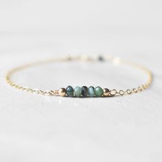 "This hand made bracelet showcases a stunning selection of raw emerald rondelles, centered on a dainty but durable chain in your preferred finish. This makes a wonderful gift for someone with a May birthday. Bracelet Size Guide: Petite: 6.5\"-7\" Average (fits most wrists): 7-8\" Large: 8-8.5\" To find your bracelet size, simply measure the circumference of your wrist by wrapping a string around it and measuring the length of the string. If you are shopping for someone else and are unsure of wha Raw Emerald, May Birthday, Birthday Bracelet, Emerald Bracelet, May Birthstone, Minimal Jewelry, Jewelry For Her, Crystal Bracelet, Wedding Bracelet