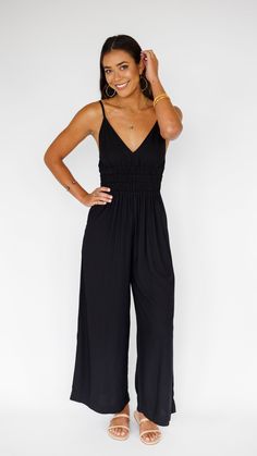 Stand out in this stunning jumpsuit, made to flow with buttery soft rayon and an exaggerated wide pant leg. Features adjustable straps and a gentle smocked waist to flatter. ** Our Model is 5'8" and wearing a size SMALL. ** Fabric & Care Instructions:100% RayonHand wash cold Line dry Vacation Wide Leg Jumpsuits With Elastic Waistband, Vacation Wide-leg Jumpsuits With Elastic Waistband, Chic Maxi Length Jumpsuits And Rompers With Elastic Waistband, Chic Smocked Bodice Jumpsuits And Rompers For Brunch, Solid Color Wide Leg Jumpsuits With Elastic Waistband, Black Summer Maxi Dress With Gathered Waist, Summer Maxi Jumpsuits And Rompers With Elastic Waistband, Sleeveless Jumpsuits And Rompers With Smocked Back For Brunch, Flowy Casual Jumpsuits And Rompers For Brunch