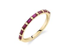 a yellow gold ring with ruby stones on the sides and a thin band around it