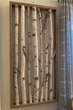 a wooden frame with birch trees in it and a vase on the table next to it