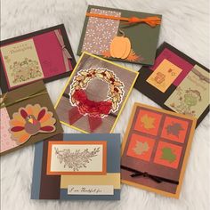 many different cards are arranged on a white furnishing area, including one with an autumn wreath and the other with fall leaves