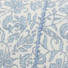 closeup of blue and white fabric with floral design on it's side,