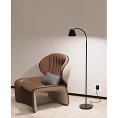 a chair with a lamp next to it and a pillow on the floor in front of it