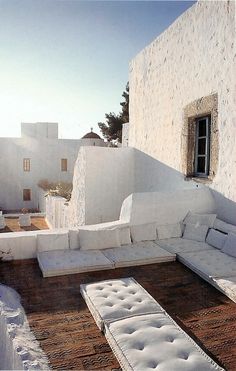 a white couch sitting on top of a wooden floor next to a wall covered in snow