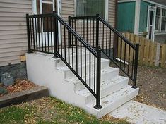 a set of stairs leading up to the front door of a house with metal railings