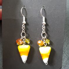 a pair of earrings with yellow and white beads