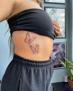 a woman with a butterfly tattoo on her stomach