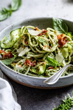 a white bowl filled with pasta covered in pesto