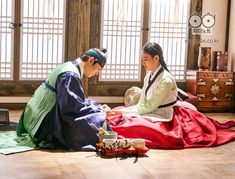 two women dressed in traditional japanese garb sitting on the floor