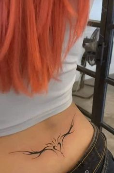 a woman with red hair has a tattoo on her stomach