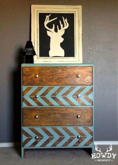 a wooden dresser with an antelope painting on it