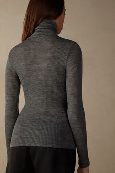 Long-sleeve high-neck tubular top made from a wool-silk blend. Fitted Elegant Merino Wool Tops, Elegant Fitted Merino Wool Tops, Stretch Merino Wool Turtleneck Top, Fine Knit High Neck Merino Wool Top, Fine Knit Merino Wool High Neck Top, High Neck Merino Wool Tops For Layering, Fitted Merino Wool Tops For Layering, Fall Merino Wool Tops With Seamless Collar, Elegant Merino Wool Funnel Neck Top