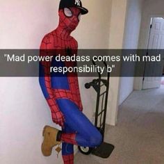 a man in a spiderman costume sitting on top of a skateboard next to a wall