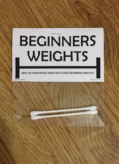 two white toothbrushes sitting on top of a wooden table next to a sign