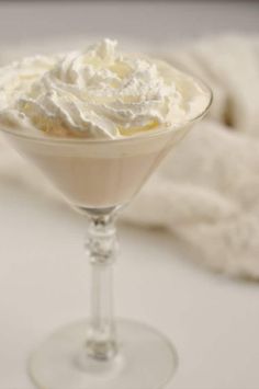 a dessert in a martini glass with whipped cream on top