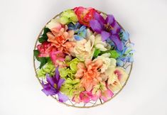 multicolored flowers in a wire basket on a white background