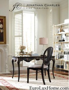 a room with a table, chair and bookcases in front of a window