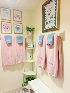 pink towels hanging on the wall in a bathroom next to a shelf with personal items