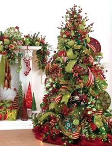 two christmas trees decorated with ribbons and bows