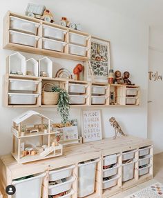 a wooden shelf filled with lots of toys and other items next to a white wall