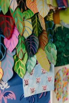 colorful paper leaves are hanging on the wall