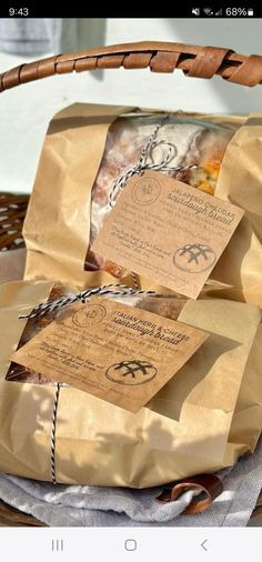 some brown paper bags sitting on top of a wooden basket filled with food and papers