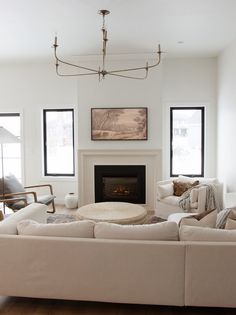 a living room filled with furniture and a fire place in the middle of a room