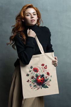 a woman holding a shopping bag with an image of a ladybug on it