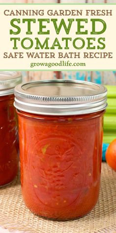 two jars filled with canned tomato sauce on top of a table next to vegetables and carrots