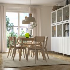 a dining room table and chairs in front of a window