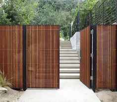 a wooden gate with metal railing and steps leading up to the top of some stairs