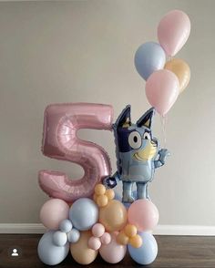 a birthday cake with balloons and the number five