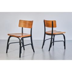 two wooden chairs sitting side by side