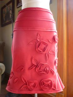 a woman's red skirt with roses on it