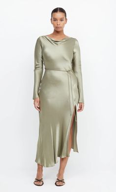 A stylish option for a cool weather wedding, the long sleeve maxi dress is cut on the bias with a cinched tie waist to create a flattering hourglass silhouette. The midi dress features a slight cowl on the high neckline with a low scoop back and leg split in the skirt. Elegant Long Sleeve Bias Cut Maxi Dress, Fitted Bias Cut Maxi Dress For Brunch, Long Sleeve Bias Cut Maxi Dress For Wedding, Formal Long Sleeve Midi Dress With Side Slits, Bias Cut Maxi Dress For Brunch, Belted Long Sleeve Maxi Dress For Night Out, Fitted Long Sleeve Bias Cut Midi Dress, Sleek Long Sleeve Midi Dress For Dinner, Fitted Maxi Dress With Tie Waist For Evening