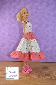 a barbie doll wearing a dress and pink shoes standing in front of a purple wall