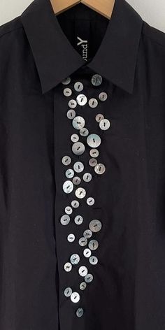 a black shirt with silver buttons on it