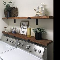 a washer and dryer sitting next to each other in a room with open shelving