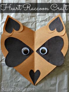 a paper heart with eyes and nose cut out to look like a dog's head