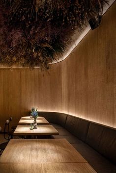 an empty restaurant with wooden tables and brown leather booths, lighting up the room above