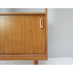 a close up of a wooden cabinet with a handle on the front and bottom part