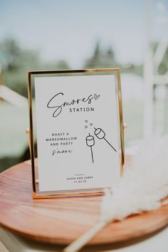 a sign that is sitting on top of a wooden table next to a white feather