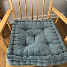 a wooden rocking chair with a blue cushion