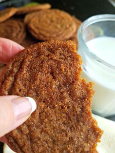 a person holding up a cookie in front of some cookies