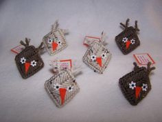 six small crocheted birds with tags attached to them