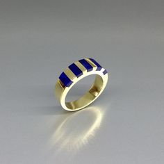 "Beautiful striped blue Lapis Lazuli ring set with solid 18k gold. Unique gift for her, wife, girlfriend, September and December birthstone, anniversary gift. This stunning ring combines Lapis Lazuli with 18K Gold in perfection. The stone is worked seamlessly into the metal. The 5 Lapis stones are worked into the gold and finishes into a band of 5mm with a thickness of 1-3mm. All our stones are natural stones and our jewelry is handmade, slight differences in color and size may occur. Our inlay Modern Channel Set Jewelry As Gift, Modern Blue Sapphire Ring In 14k Gold, Modern Blue Sapphire Ring Hallmarked, Minimalist Blue Rectangular Ring, Minimalist Channel Set Rings For Gifts, Blue Modernist Jewelry With Polished Finish, Modernist Blue Jewelry With Polished Finish, Modern Hallmarked Sapphire Ring As Gift, Modern Blue Jewelry For Anniversary