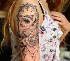 a woman with a tattoo on her arm has an owl and roses in the frame