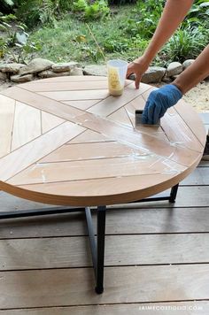 a person is sanding the top of a table